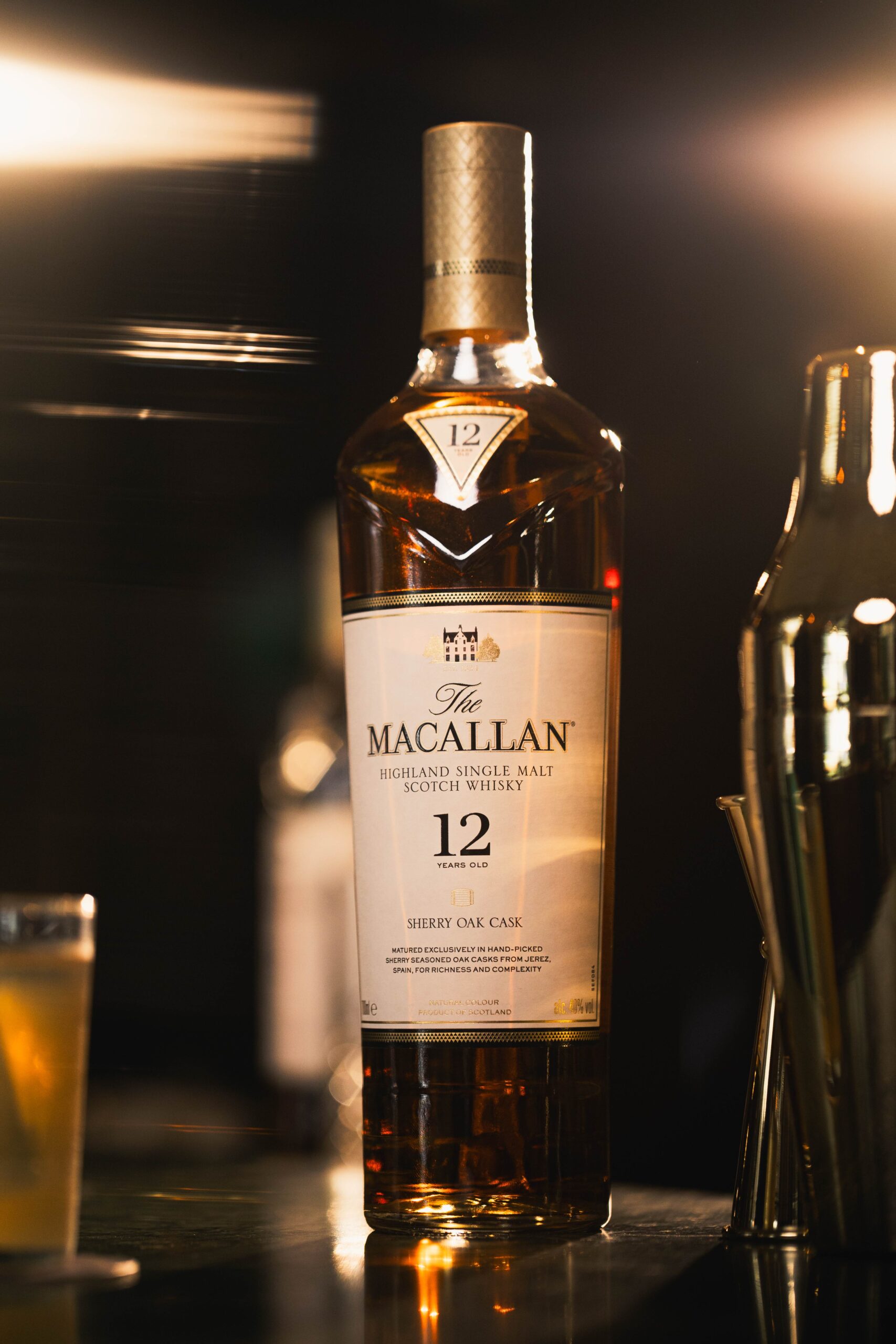 Fotografia profissional de produto da garrafa de whisky The Macallan 12 anos com iluminação dramática de estúdio.