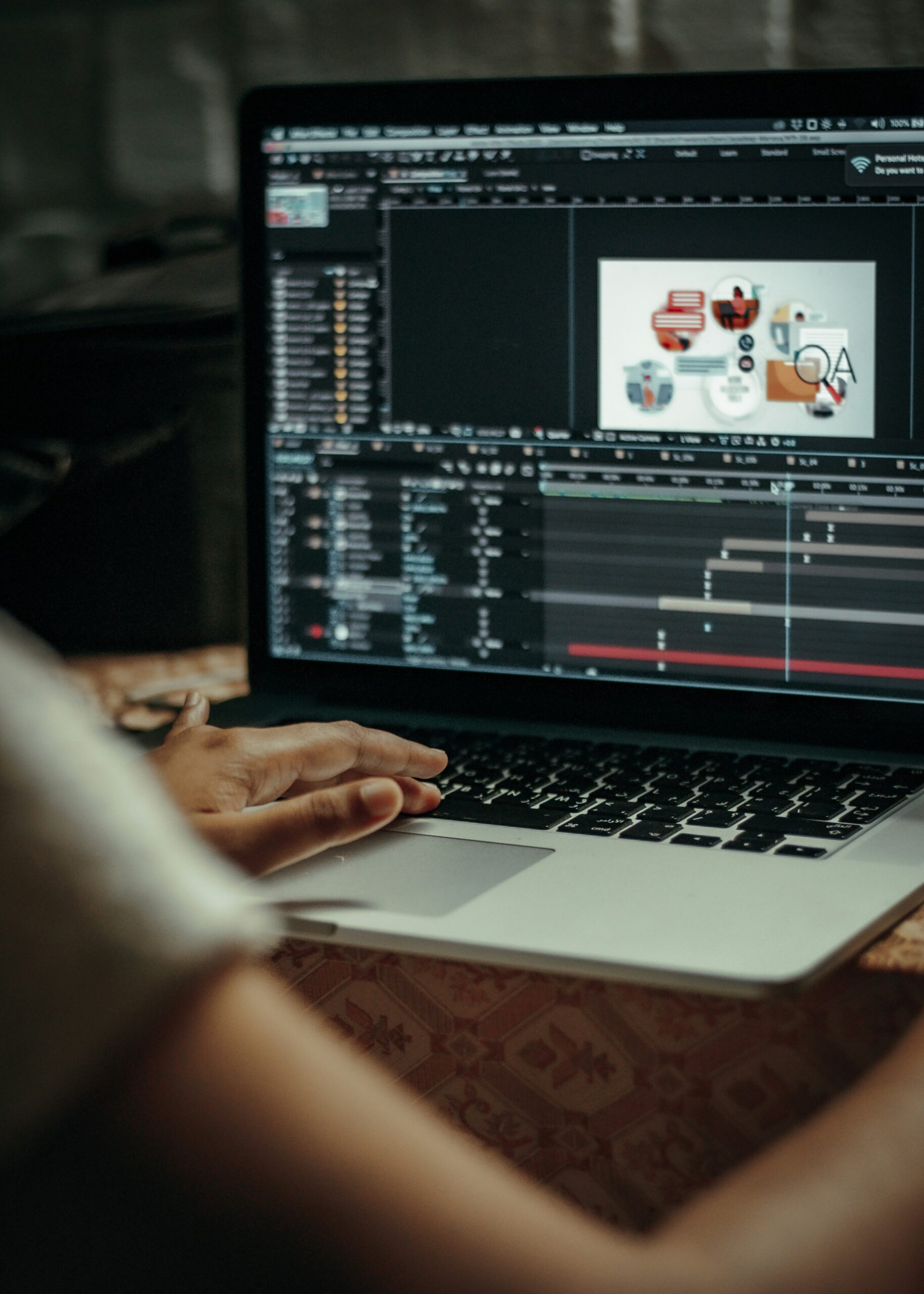 Pessoa editando vídeo e elementos gráficos em linha do tempo de software no notebook
